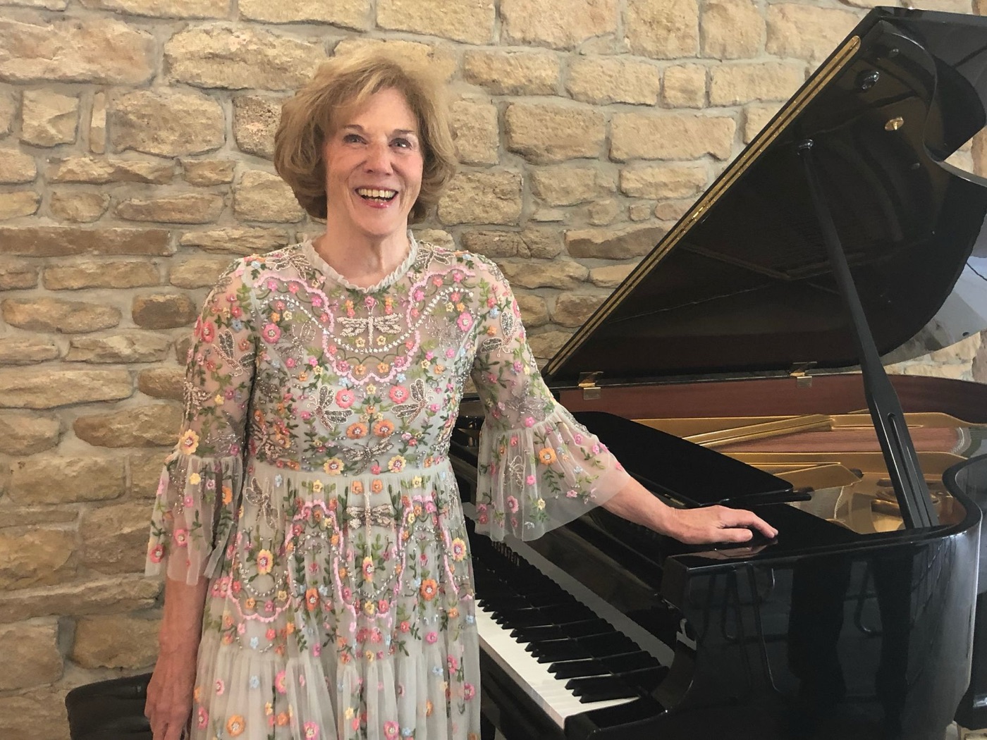 Margaret Bruce beside a grand piano