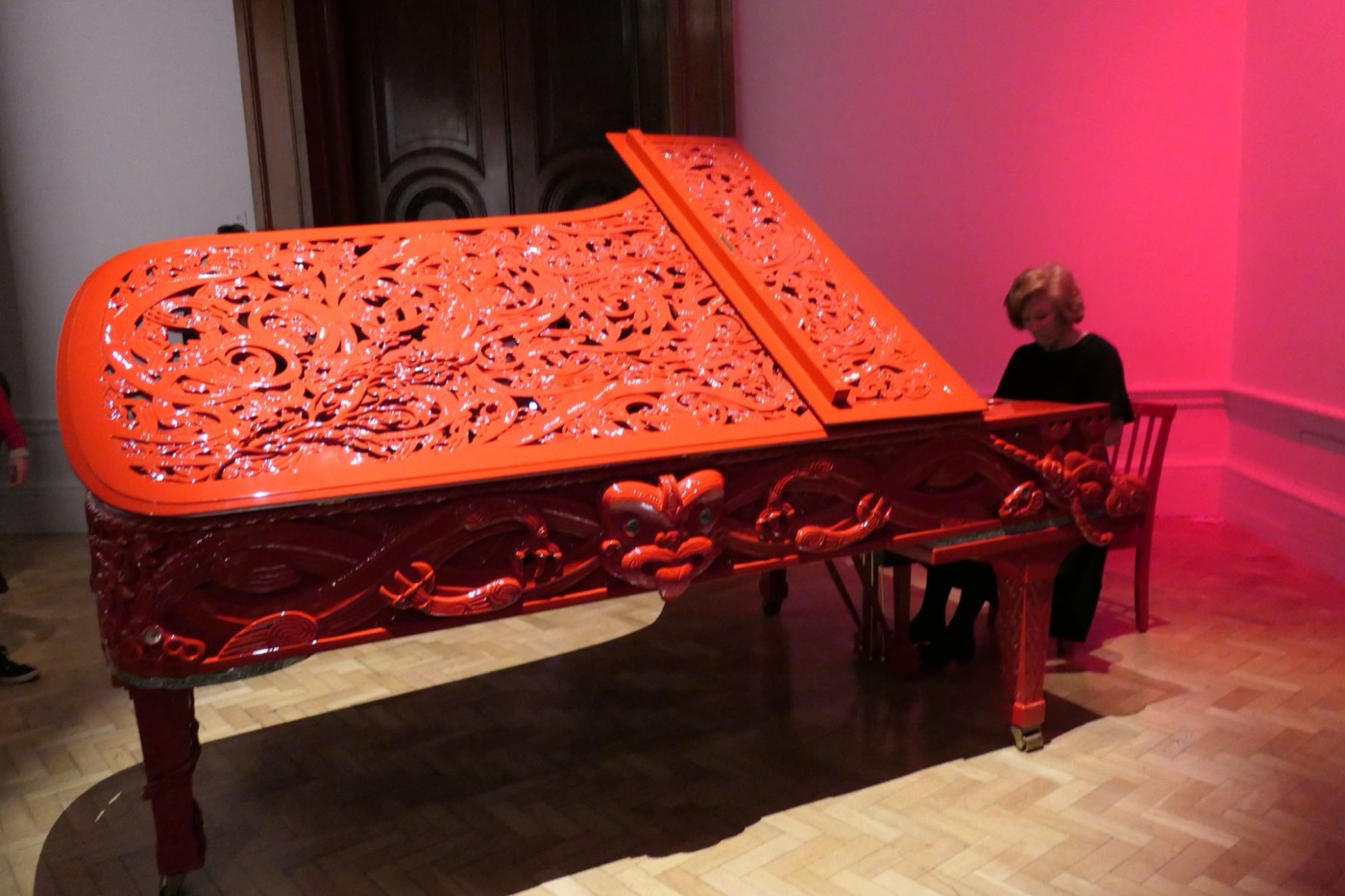 An ornate red grand piano